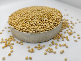 Millet seeds in a bowl on a white background, subject photography.