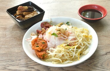 steamed large rice noodles topping slice fried Chinese sausage and crispy pork belly with bean sprout dressing black soy sauce on plate dipping sour soybean sauce