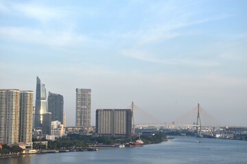 Fototapeta premium bridge and building cityscape on river in sunset at Thailand