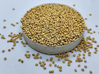 Millet seeds in a bowl on a white background, subject photography.