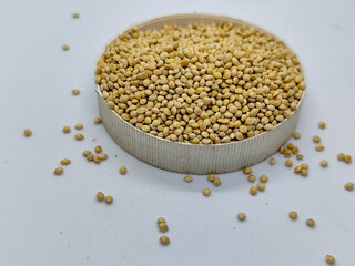 Millet seeds in a bowl on a white background, subject photography.