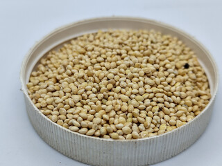 Millet seeds in a bowl on a white background, subject photography.