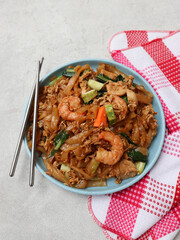 Kwetiaw or Kwetiau seafood, fried rice noodles with prawn or shrimp and vegetables. Popular in...
