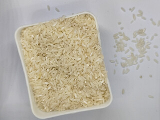 Unprocessed rice, on a natural blurred white background.