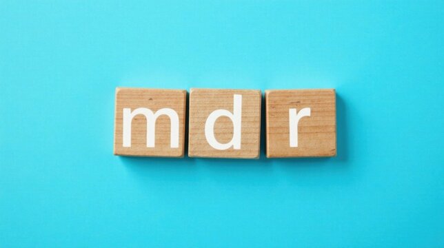 Wooden blocks spelling out the letters mdr on a light blue background