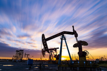 In the evening, oil pumps are running, Silhouette of beam pumping unit