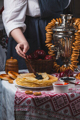 A woman's hand puts black caviar on a pancake