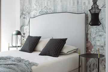 Comfortable bed adorned with plush pillows and a cozy blanket, nestled in a modern bedroom...