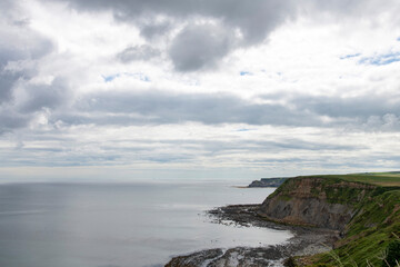 Panoramic view over the coastline with tranquil water in the sea and steeps cliffs between Saltburn-by-the-Sea and Whitby, UK