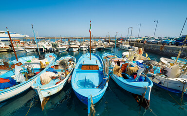 Fototapeta premium Colorful fishing boats moored in Marina Grande harbor on island of Capri, Italy. Scene highlights charm of Mediterranean life and vibrant colors typical of Capri