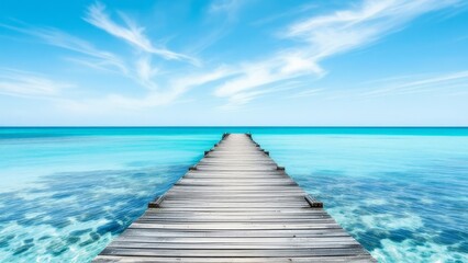 Perspective view of a wooden pier extending into a calm, turquoise sea under a clear blue sky
