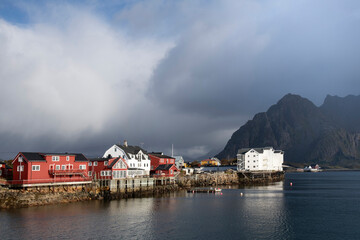 View over harbor at low tide lined with colorful buildings in Henningsvaer, Norway on Lofoten...