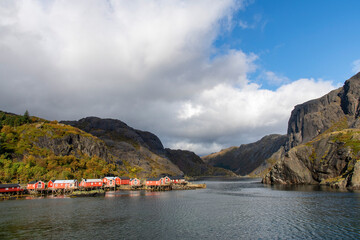 View over a sunny fjord near Nusfjord, Norway with characteristic red (fisherman) cabins (rorbu) on...