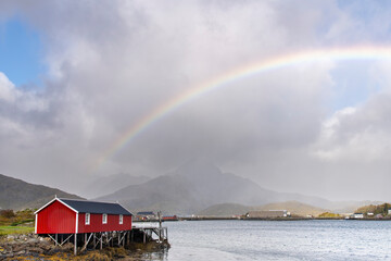 View over a fjord near Reine, Norway on Lofoten island chain archipelago with typical red...
