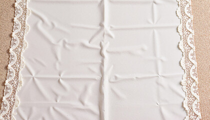 Obraz premium Elegant white lace tablecloth on a textured background 