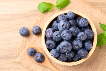 Blueberries in wooden bowl with spoon, Healthy fruit, Food ingredient, Table top view