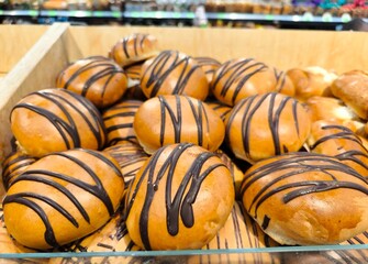 fresh pastries at the bakery store. Assortment of sweet pastries on the cafe counter, bread roll with poppy seeds, cinnamon and raisins.