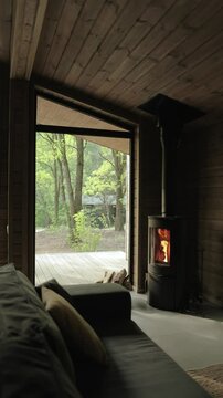 An inviting, cozy indoor scene featuring a warm fireplace and a breathtaking scenic view of nature. Vertical video
