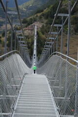 The Andorra Tibetan Bridge, known as Pont Tibetà Canillo, stretches high above a deep valley, offering stunning views of the surrounding mountains and landscape.

