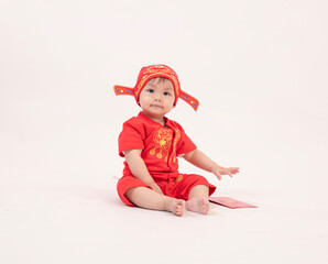 Asian boy in cheongsam with red envelope on white background