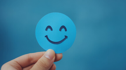 Hand Holding Smiley Face on Blue Background