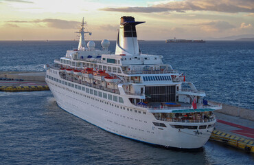 Luxury classic cruiseship cruise ship liner Discovery during sunrise twilight dawn laid up in port of Piraeus, Athens Greece with city skyline and oceanscape horizon view