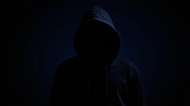 Silhouette of a hooded figure in low light, obscuring identity, on a dark background. Concept of mystery, anonymity, and secrecy. Ai generative