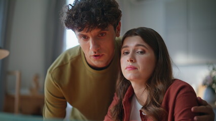 Disappointed pair discussing project problems looking laptop screen closeup