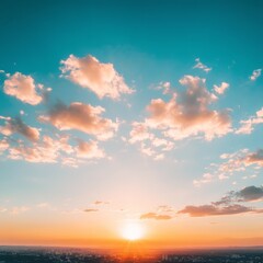 Fototapeta premium Scenic sunset over cityscape with vibrant orange and teal sky, fluffy clouds.