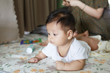 a baby laying on a bed next to a woman
