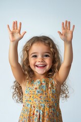 Young girl with curly hair expresses excitement with hands raised in joyful celebration indoors