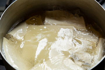 The dough for khinkali is thin and boiled in meat broth in a saucepan. Horizontal photo.