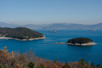 Obraz premium Coastal view with islands and cargo ships