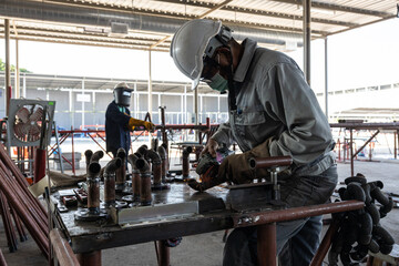 Welder Working on Metal Pipes in Workshop