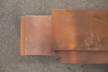 Stack of Copper Sheets on Concrete Surface
