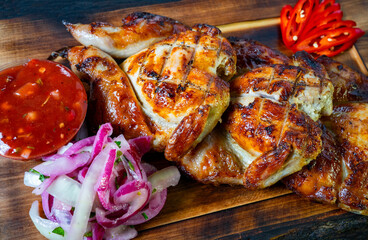 Grilled chicken served with fresh salsa and onion salad