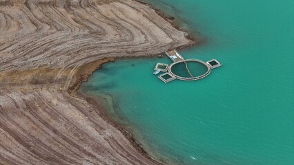 blue lake Burug is covered with multi-colored stones; a backwater for fish breeding has been...