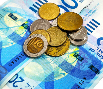 
Israeli coins against the background of a 200 shekel bill. Israeli currency and money. Background