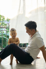 there is a man sitting on the floor with a baby