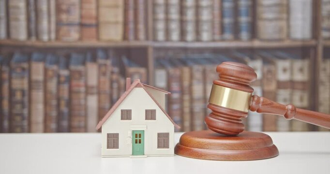 Legal issues, property, real estate law and transactions. A residential house beside the judge's gavel. The intersection of law and real estate in various aspect e.g property rights, contract, etc
