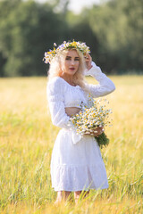 Portrait of a young beautiful blonde girl in nature in summer.