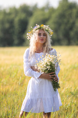 Portrait of a young beautiful blonde girl in nature in summer.