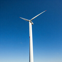 wind turbine against blue sky. Low angle of wind turbine against bright blue sky. Renewable or green energy concept. landscape of windmill with sunlight and almost clear sky.