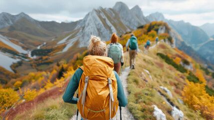 Travelers backpacker hiking through a scenic mountain trail. Winter travel adventure with snow capped on hill view in autumn