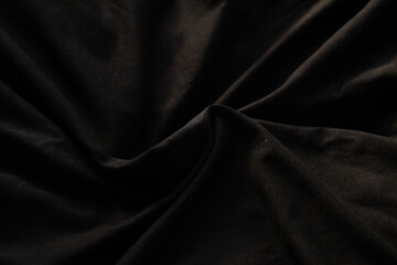 Draped black fabric with subtle folds and shadows.  Perfect for backgrounds, textures, or design...
