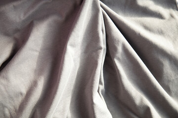 Soft, draped gray fabric with subtle texture and light play. Ideal for textile, fashion, or design...