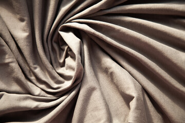 Swirling taupe fabric texture. Soft, luxurious textile background. Perfect for design projects...