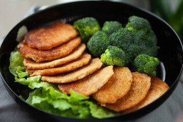Delicious golden-brown patties served with steamed broccoli and fresh lettuce.