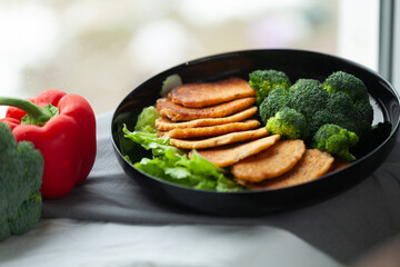 Healthy and delicious meal: pan-fried patties served with steamed broccoli and lettuce.