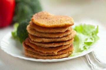 A stack of golden-brown pancakes sits on a plate garnished with lettuce.  A healthy and delicious breakfast or snack.